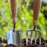 garden tools stabbed into soil