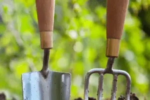 garden tools stabbed into soil