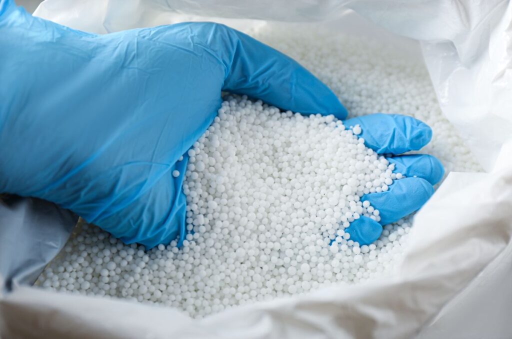 holding synthetic fertilizer while wearing a glove